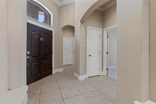 3804 Park Flower Ct, Arlington, TX 76017 - foyer entrance with arched walkways, ornamental molding, light tile patterned floors, and a textured wall