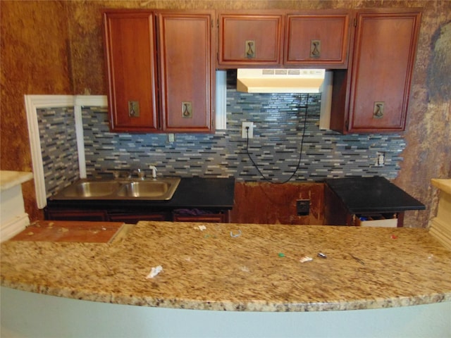2906 Swanson St, Dallas, TX 75210 - kitchen with under cabinet range hood, tasteful backsplash, and light stone counters