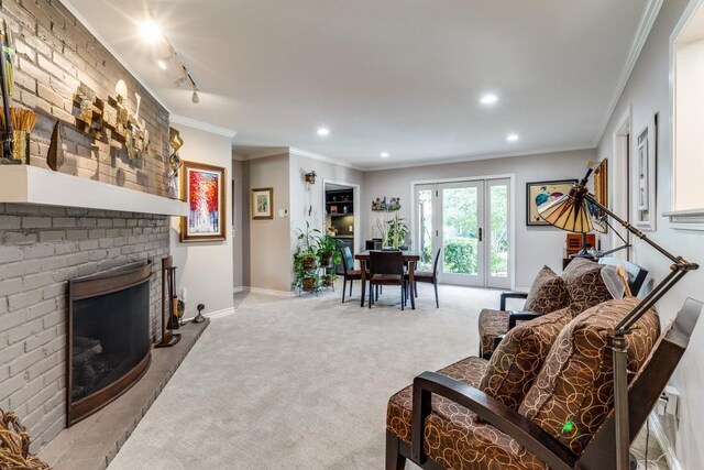 5715 Northaven Rd, Dallas, TX 75230 - carpeted living room featuring crown molding, recessed lighting, and a brick fireplace
