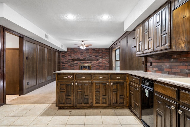2214 Parkside Dr, Denton, TX 76201 - kitchen featuring a ceiling fan, a peninsula, a textured ceiling, a fireplace, and dark brown cabinetry