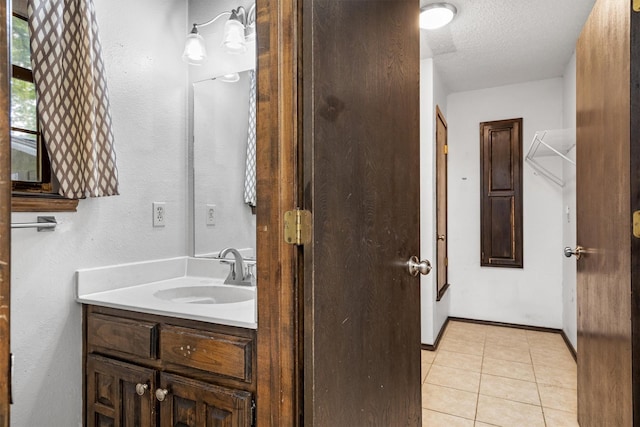 2214 Parkside Dr, Denton, TX 76201 - bathroom featuring vanity, tile patterned floors, and a textured ceiling