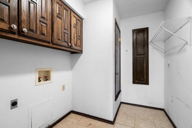 2214 Parkside Dr, Denton, TX 76201 - laundry area featuring electric dryer hookup, hookup for a washing machine, cabinet space, and light tile patterned floors