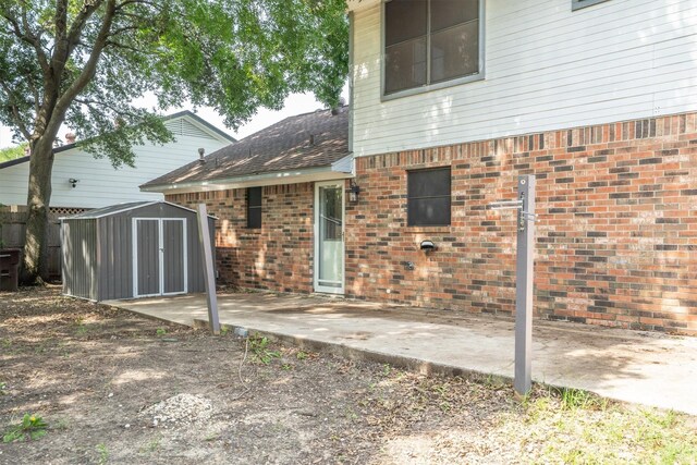 2214 Parkside Dr, Denton, TX 76201 - back of house featuring a shed, a patio, brick siding, and a shingled roof