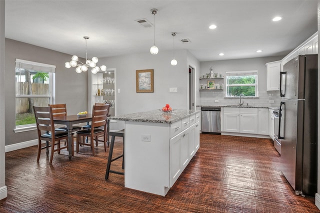 2711 El Tivoli Dr, Dallas, TX 75211 - kitchen featuring freestanding refrigerator, dishwasher, a center island, tasteful backsplash, and white cabinets