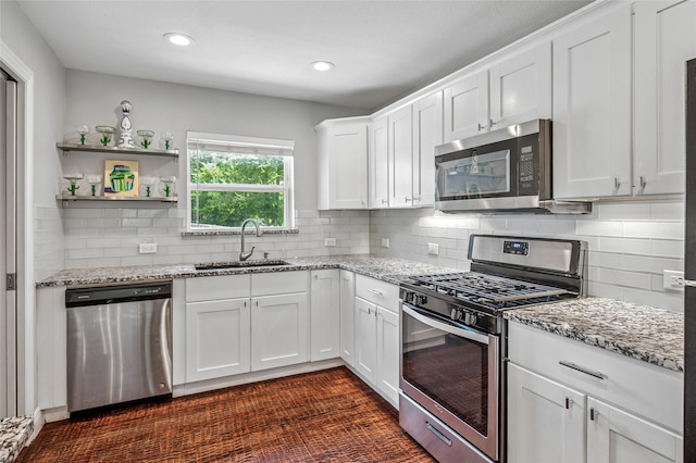 2711 El Tivoli Dr, Dallas, TX 75211 - kitchen featuring appliances with stainless steel finishes, white cabinetry, light stone counters, backsplash, and recessed lighting