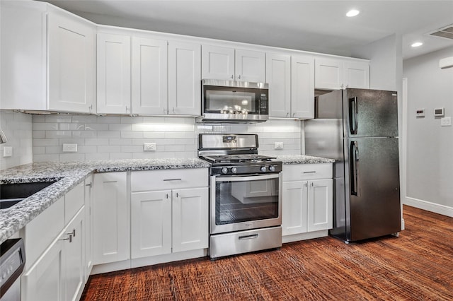 2711 El Tivoli Dr, Dallas, TX 75211 - kitchen featuring appliances with stainless steel finishes, white cabinetry, recessed lighting, tasteful backsplash, and light stone counters