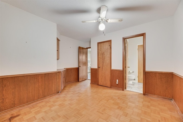 13861 Far Hills Ln, Dallas, TX 75240 - unfurnished room featuring wainscoting, wooden walls, and a ceiling fan