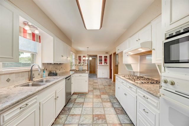 13861 Far Hills Ln, Dallas, TX 75240 - kitchen with stainless steel appliances, premium range hood, stone finish floors, a chandelier, and white cabinets
