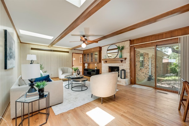 13861 Far Hills Ln, Dallas, TX 75240 - living room featuring a skylight, beamed ceiling, a fireplace, wood finished floors, and wooden walls