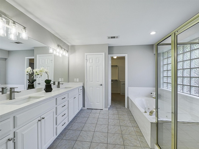 925 Canongate Dr, Flower Mound, TX 75022 - bathroom with double vanity, a garden tub, recessed lighting, tile patterned floors, and a spacious closet