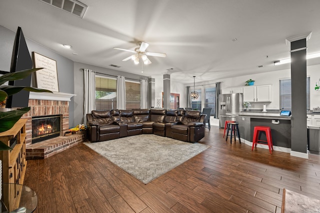 13341 Ridgepointe Rd, Fort Worth, TX 76244 - living room with ceiling fan, ornate columns, dark wood-type flooring, and a fireplace