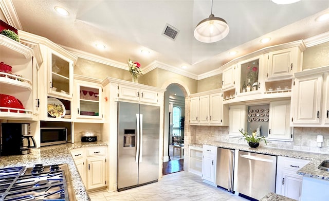 1450 Meandering Way, Rockwall, TX 75087 - kitchen with stainless steel appliances, ornamental molding, open shelves, light stone countertops, and arched walkways
