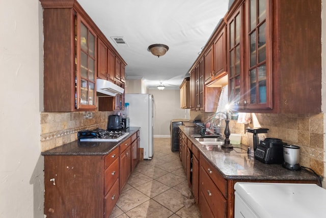 735 Wren Ave, Duncanville, TX 75116 - kitchen featuring under cabinet range hood, tasteful backsplash, glass insert cabinets, stainless steel gas cooktop, and light tile patterned floors