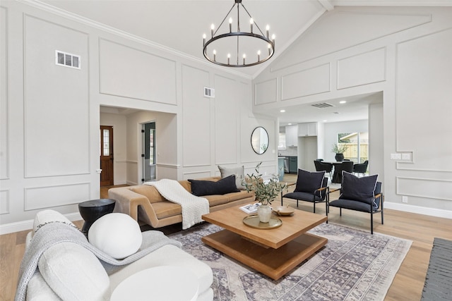 1100 Longworth Dr, Plano, TX 75075 - living area featuring a decorative wall, light wood-style floors, a chandelier, and high vaulted ceiling