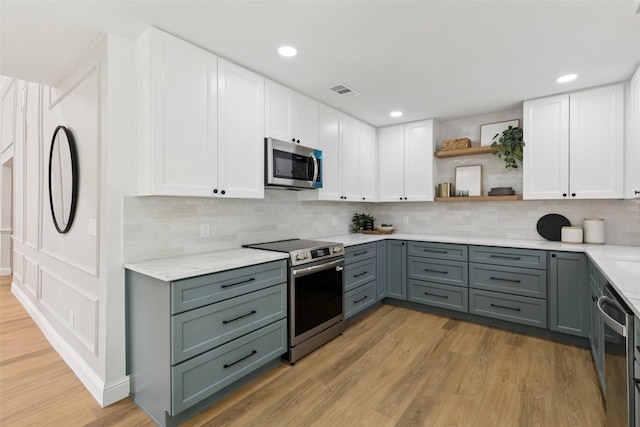 1100 Longworth Dr, Plano, TX 75075 - kitchen featuring appliances with stainless steel finishes, open shelves, white cabinetry, light wood-style floors, and recessed lighting