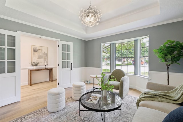 1100 Longworth Dr, Plano, TX 75075 - living area featuring a tray ceiling, wood finished floors, a chandelier, and ornamental molding