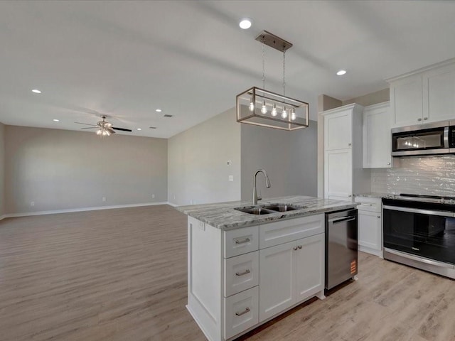106 Saddle Brook Dr, Lufkin, TX 75904 - kitchen with stainless steel appliances, light wood-style floors, white cabinets, recessed lighting, and tasteful backsplash