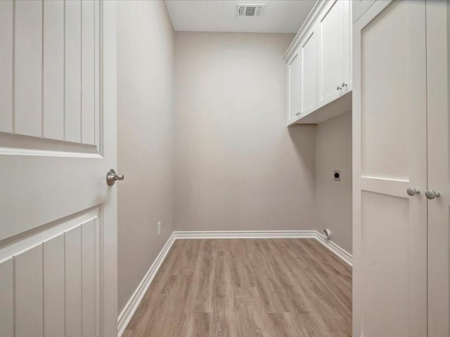 106 Saddle Brook Dr, Lufkin, TX 75904 - laundry area featuring hookup for an electric dryer, cabinet space, and light wood-style floors
