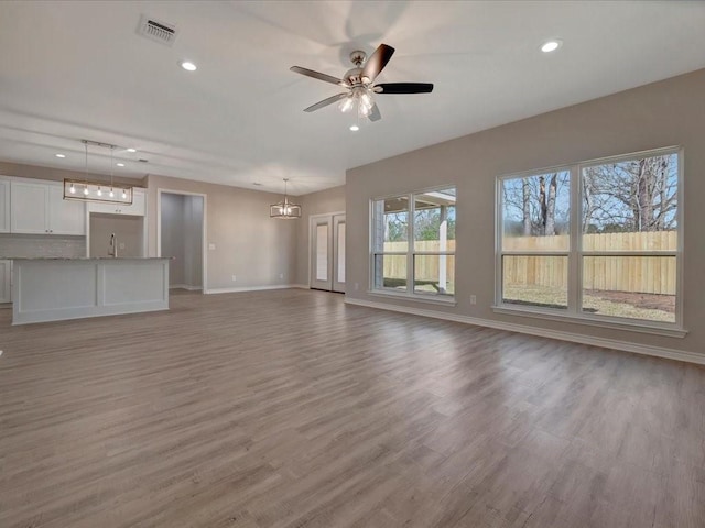 106 Saddle Brook Dr, Lufkin, TX 75904 - unfurnished living room featuring recessed lighting, a ceiling fan, light wood-style flooring, and a chandelier