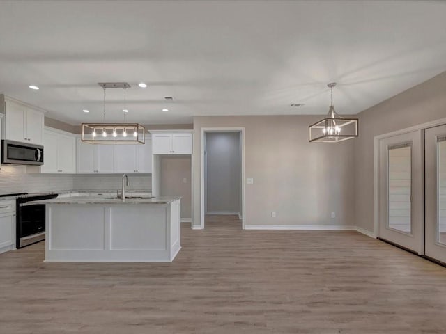 106 Saddle Brook Dr, Lufkin, TX 75904 - kitchen featuring appliances with stainless steel finishes, backsplash, a chandelier, light wood-style floors, and white cabinets
