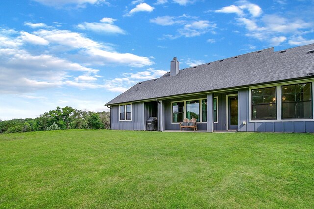 619 Latigo Ct, Weatherford, TX 76088 - back of property featuring a chimney, a yard, a shingled roof, and board and batten siding