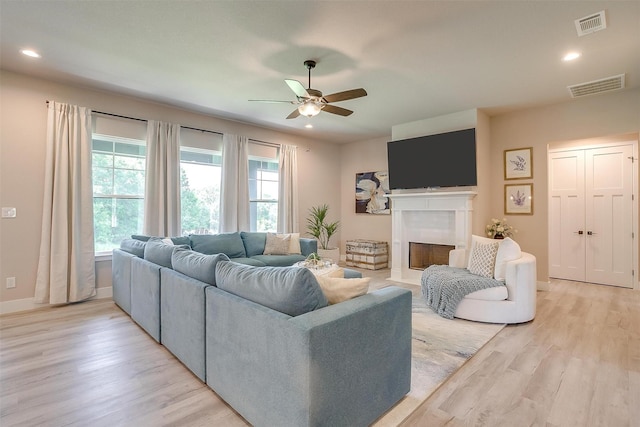 619 Latigo Ct, Weatherford, TX 76088 - living room featuring a ceiling fan, light wood-style floors, a fireplace with flush hearth, and recessed lighting