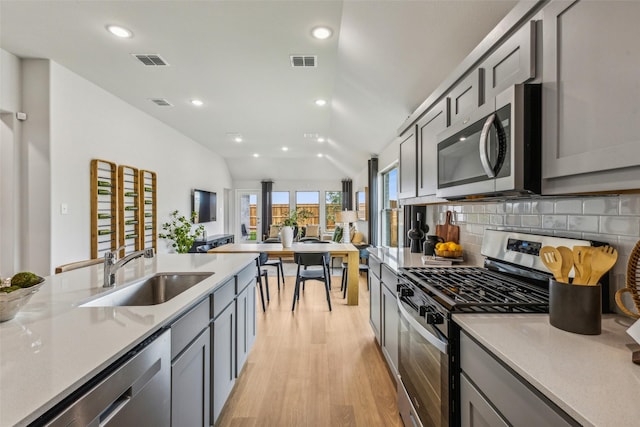 259 Bright Alcove Ct, Lavon, TX 75166 - kitchen featuring stainless steel appliances, light wood finished floors, gray cabinetry, backsplash, and recessed lighting