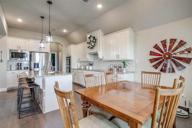 404 Bluffside Trl, Benbrook, TX 76126 - dining area with dark wood-style flooring, arched walkways, lofted ceiling, and recessed lighting
