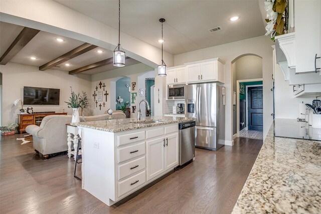 404 Bluffside Trl, Benbrook, TX 76126 - kitchen featuring appliances with stainless steel finishes, open floor plan, arched walkways, white cabinets, and recessed lighting