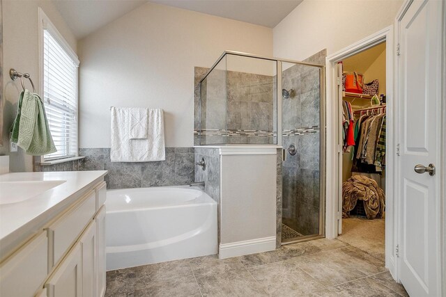 404 Bluffside Trl, Benbrook, TX 76126 - bathroom with a stall shower, a bath, a spacious closet, vanity, and lofted ceiling