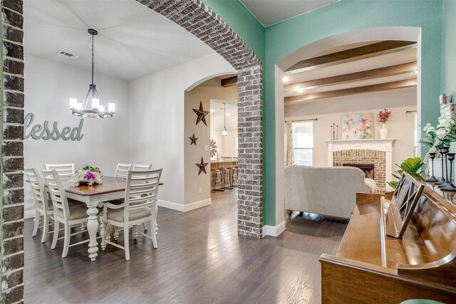 404 Bluffside Trl, Benbrook, TX 76126 - dining room with dark wood finished floors, arched walkways, a brick fireplace, and a chandelier