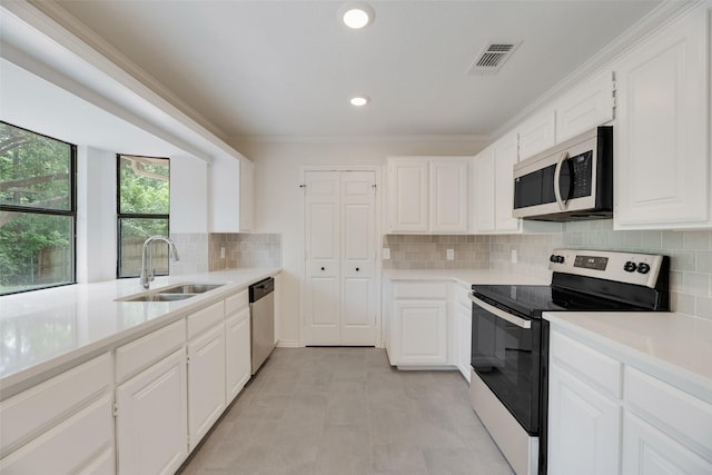 3801 Woodside Dr, Arlington, TX 76016 - kitchen with stainless steel appliances, light countertops, white cabinetry, backsplash, and crown molding