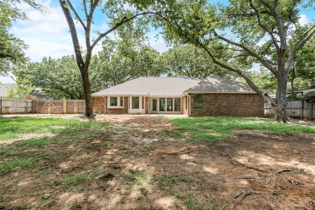 3801 Woodside Dr, Arlington, TX 76016 - rear view of property featuring brick siding, a fenced backyard, and roof with shingles