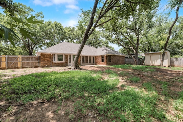 3801 Woodside Dr, Arlington, TX 76016 - back of house featuring a storage shed, a fenced backyard, and brick siding