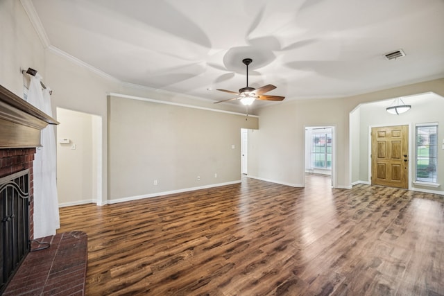 700 Lake Vista Ln, Lavon, TX 75166 - unfurnished living room featuring dark wood-type flooring, crown molding, ceiling fan, a fireplace, and arched walkways