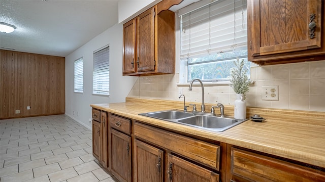 217 Wintercrest Rd, Burleson, TX 76028 - kitchen with brown cabinetry, tasteful backsplash, light countertops, and wood walls