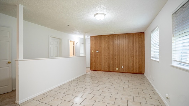 217 Wintercrest Rd, Burleson, TX 76028 - unfurnished room with wood walls, a textured ceiling, and plenty of natural light