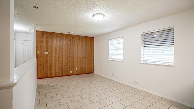 217 Wintercrest Rd, Burleson, TX 76028 - spare room featuring wooden walls and a textured ceiling