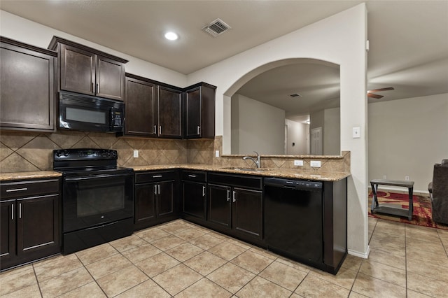 6625 Vista View Dr, Woodway, TX 76712 - kitchen with black appliances, light tile patterned floors, backsplash, arched walkways, and recessed lighting