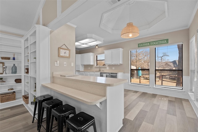 111 Hickory Creek Cir, Gun Barrel City, TX 75156 - kitchen with light countertops, a breakfast bar, light wood-type flooring, white cabinets, and pendant lighting