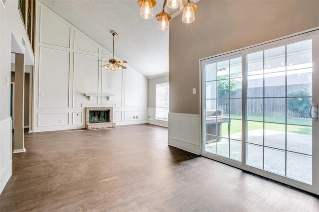 403 Gingerbread Ln, Waxahachie, TX 75165 - unfurnished living room with high vaulted ceiling, a decorative wall, a chandelier, a fireplace, and wood finished floors