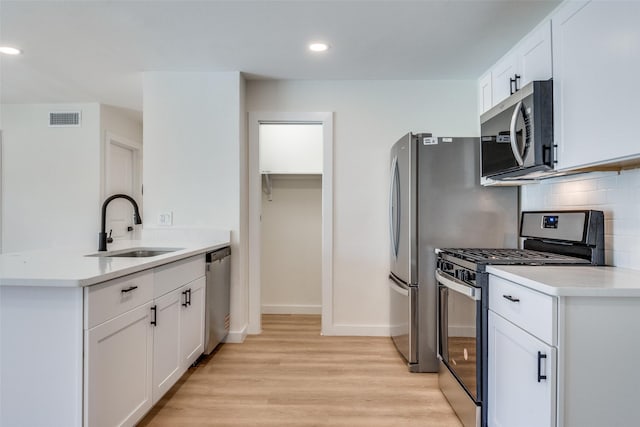 118 W Wanda Dr, Garland, TX 75040 - kitchen featuring stainless steel appliances, light wood-style flooring, backsplash, recessed lighting, and white cabinetry