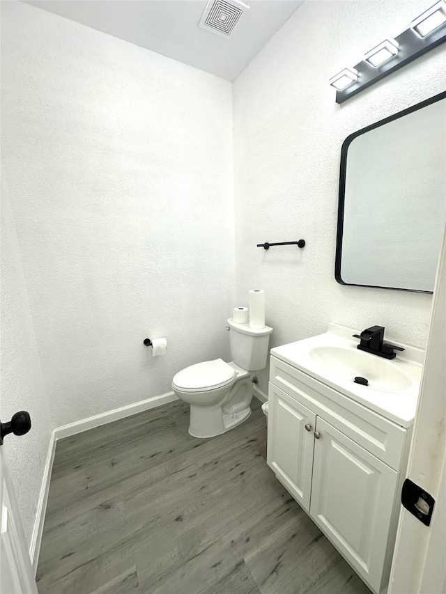 4201 Iron Ln, Mansfield, TX 76063 - half bath with wood finished floors, vanity, and a textured wall