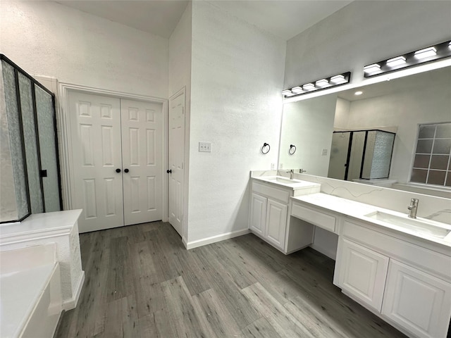4201 Iron Ln, Mansfield, TX 76063 - bathroom featuring a stall shower, wood finished floors, double vanity, and a garden tub