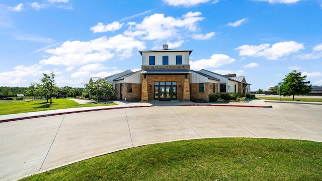 2026 Ocelot St, Crandall, TX 75114 - view of front of house featuring french doors, a front yard, brick siding, and board and batten siding