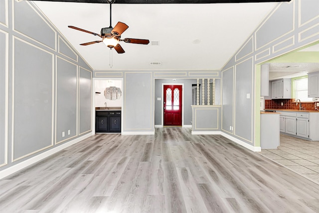4005 Azalea Ln, Garland, TX 75043 - unfurnished living room featuring a decorative wall, lofted ceiling, ceiling fan, light wood-style floors, and ornamental molding
