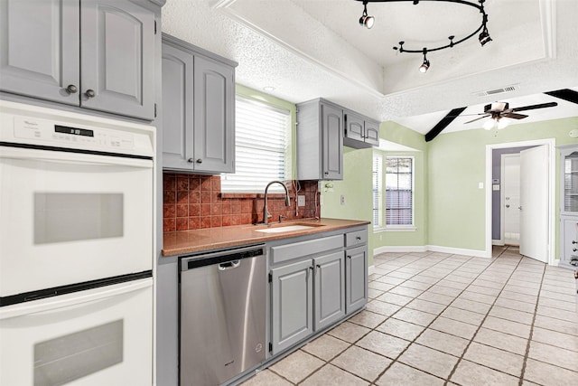 4005 Azalea Ln, Garland, TX 75043 - kitchen featuring stainless steel dishwasher, gray cabinets, white double oven, tasteful backsplash, and light tile patterned flooring