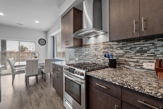 1154 Holcombe Dr, Anna, TX 75409 - kitchen with wall chimney exhaust hood, gas range, dark brown cabinets, wood finished floors, and stone counters