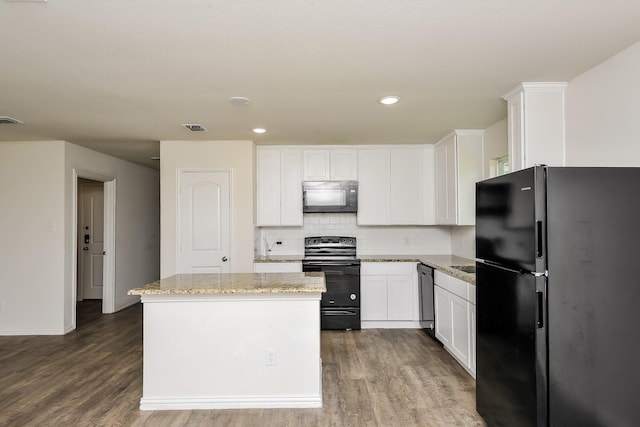2719 William St, Mabank, TX 75147 - kitchen with black appliances, dark wood-style flooring, a center island, white cabinetry, and recessed lighting