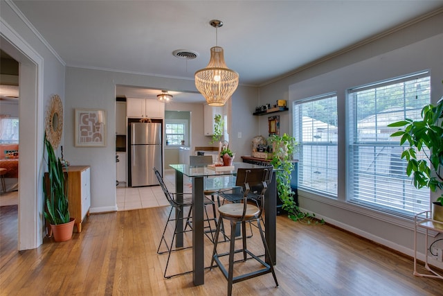 1211 Lansford Ave, Dallas, TX 75224 - dining room featuring light wood-style flooring, crown molding, and a chandelier